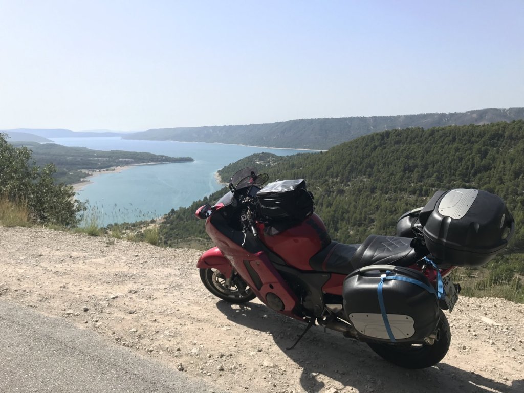 Rotes Motorrad am Straßenrand über dem türkisfarbenen Lac de Sainte-Croix