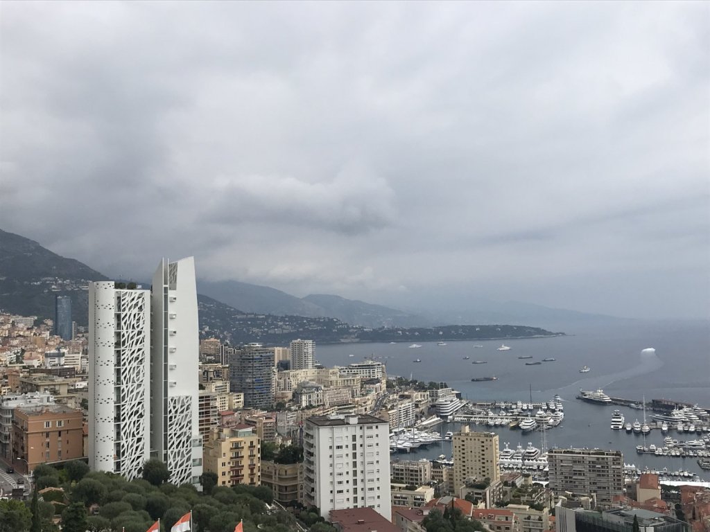 Hochhäuser und Hafen von Monaco unter dunklen Wolken