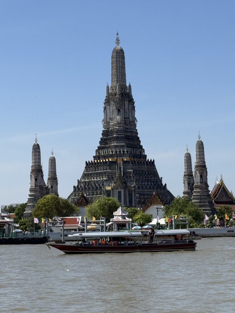 Wat Arun am Fluss Chao Phraya mit Langboot im Vordergrund