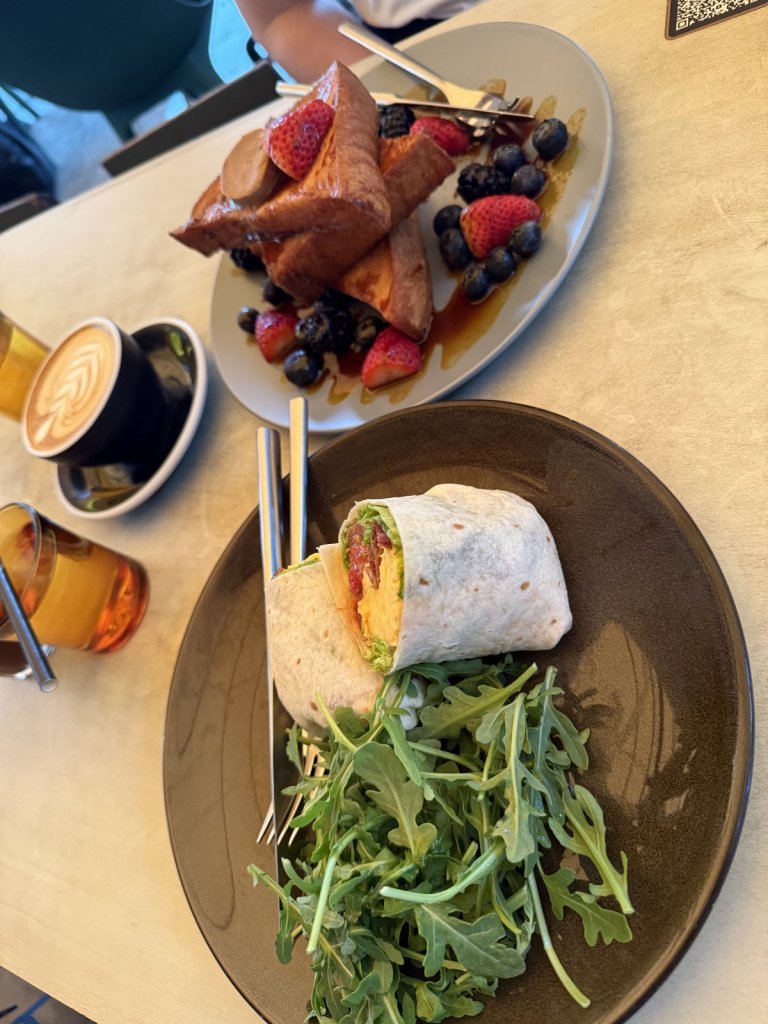 Teller mit French Toast und Beeren sowie ein Wrap mit Rucola