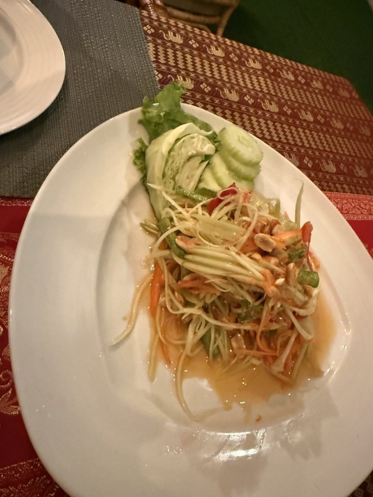 Papayasalat mit Gurke und Tomate auf einem weißen Teller