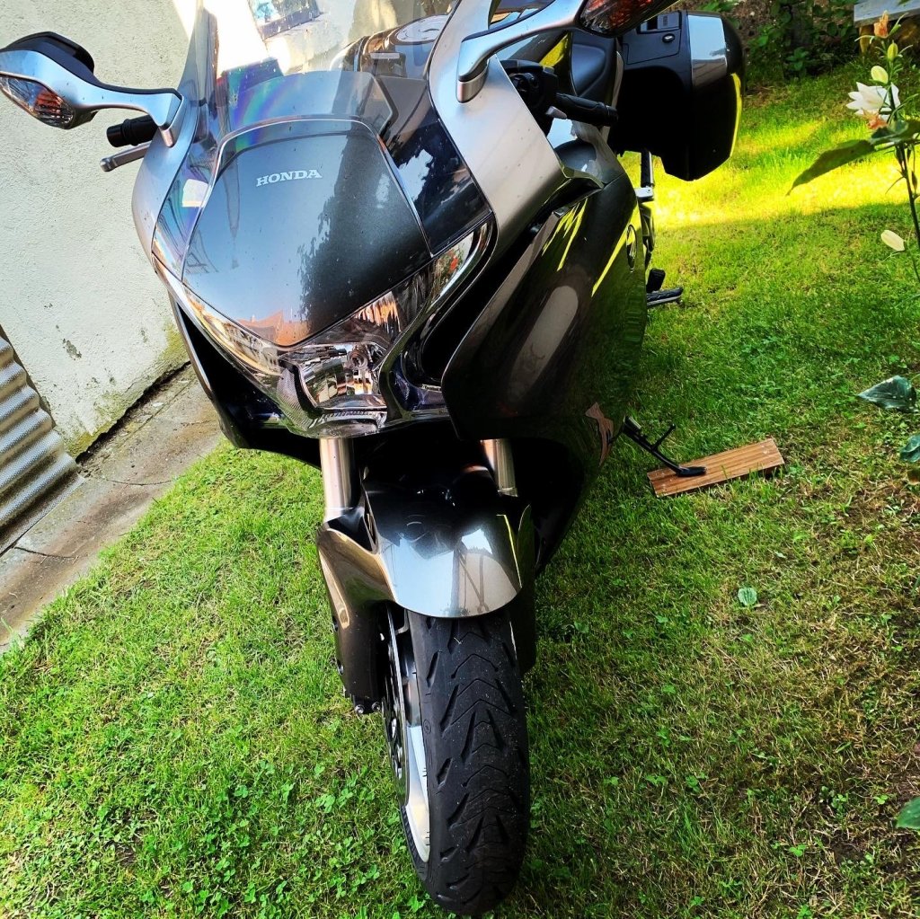 Graue Honda VFR auf einer grünen Wiese in einem Garten