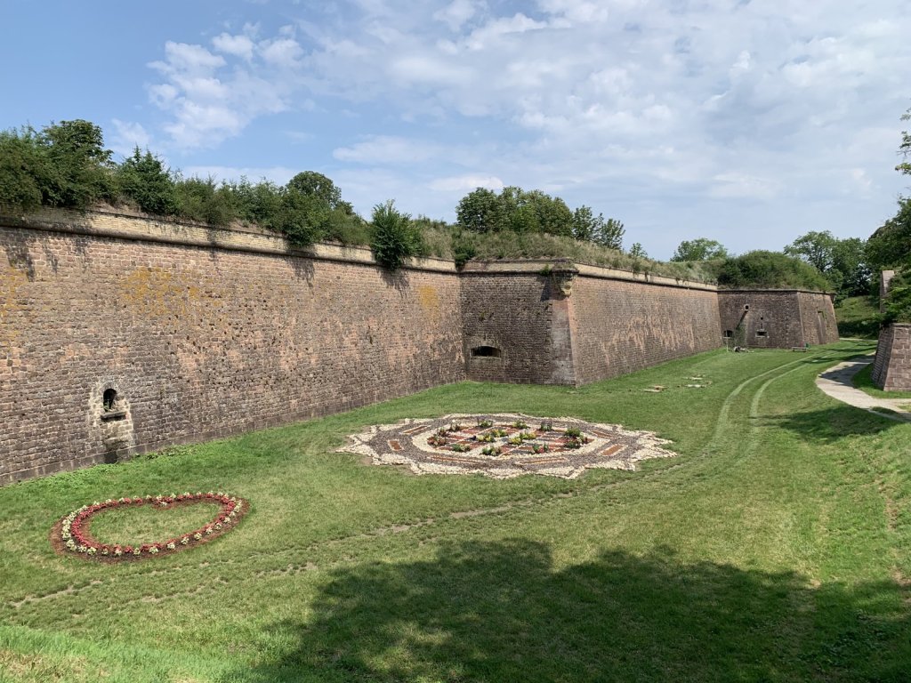 Backsteinmauern und Wassergräben der Festungsstadt Neuf-Brisach mit Blumenbeet