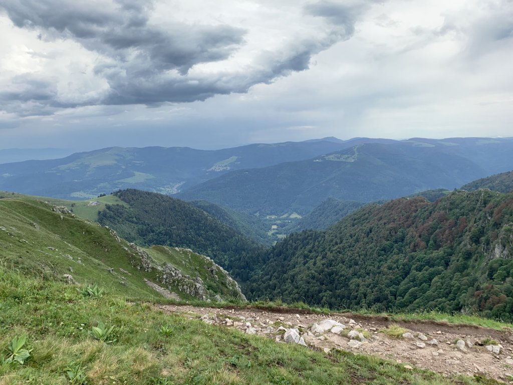 Grüne Bergkämme der Hochvogesen unter dunklen Wolken