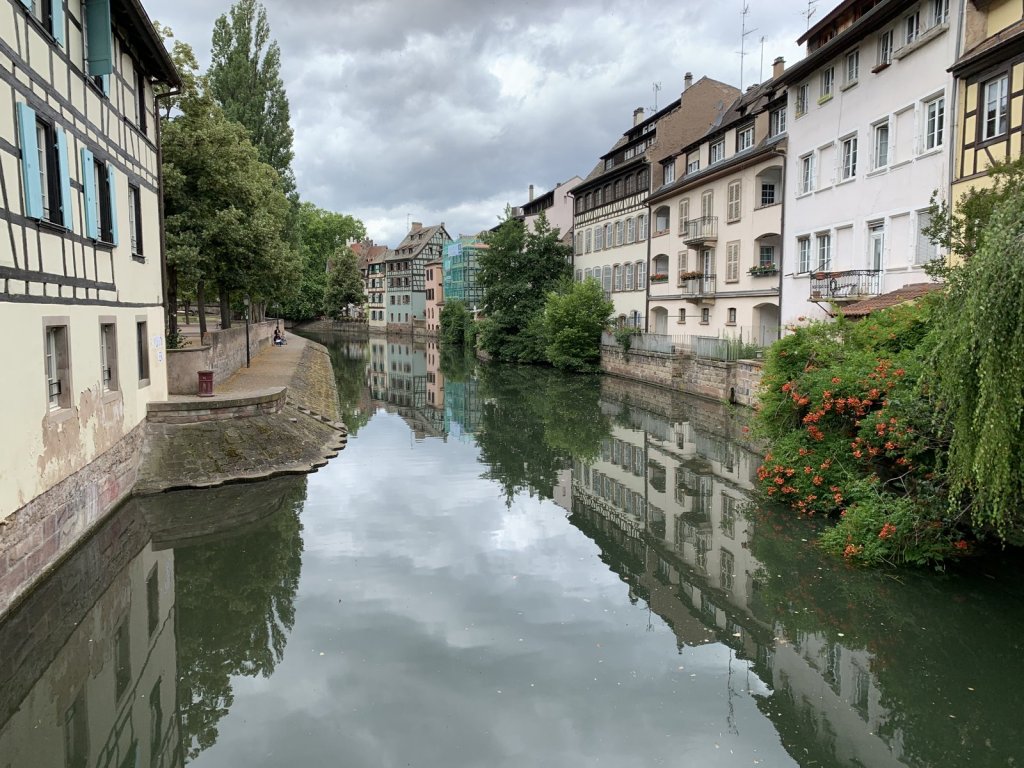 Fachwerkhäuser spiegeln sich im Wasser eines Kanals in Straßburg