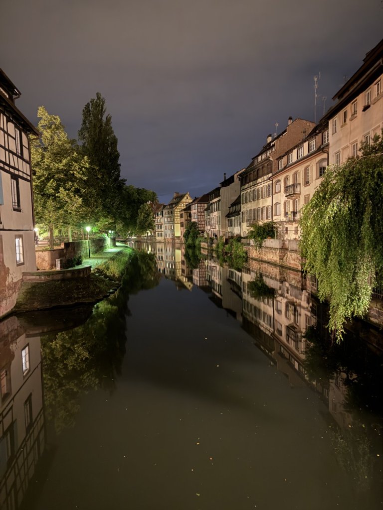 Spiegelungen von Fachwerkhäusern und Bäumen im Kanal in Straßburg