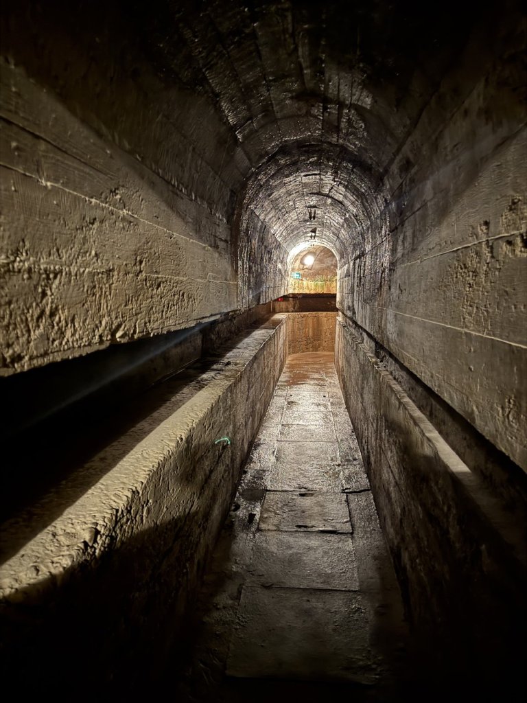 Langer gemauerter Tunnel mit Wasserrinne in einer Festungsanlage