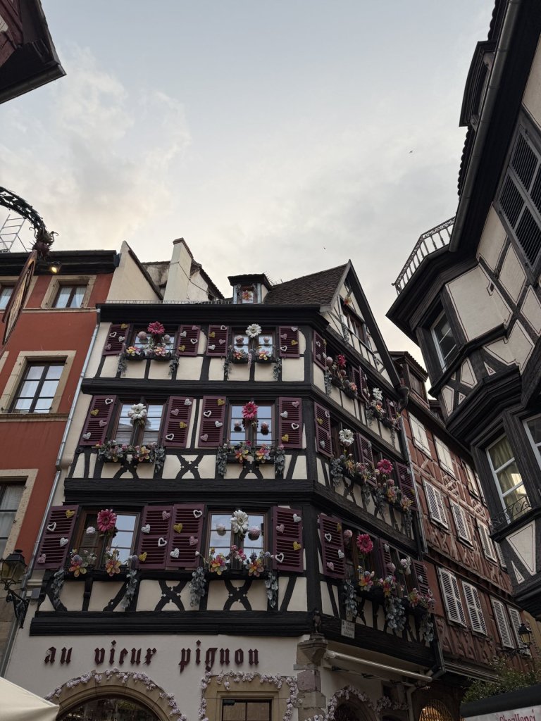 Großes Fachwerkhaus mit Blumenschmuck an den Fenstern in Colmar