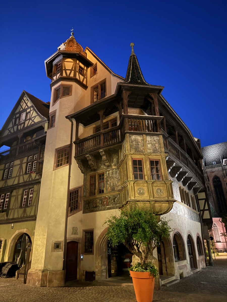 Renaissance-Haus mit holzverkleidetem Erker und Turm in Colmar am Abend