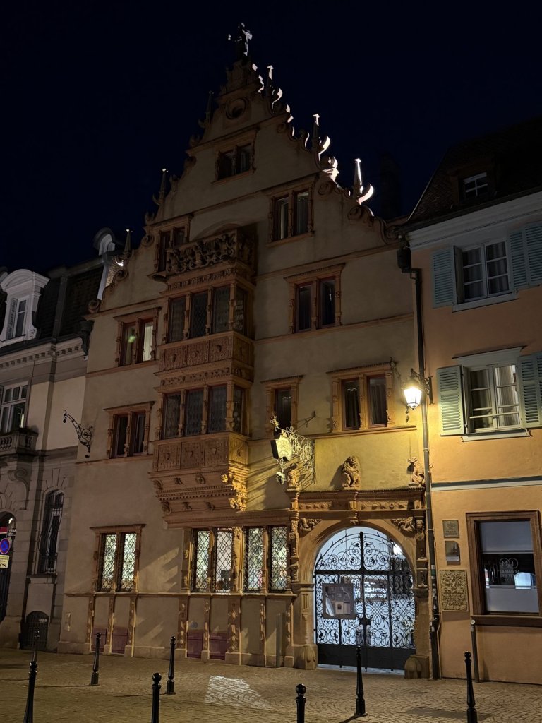Verzierte Renaissance-Fassade mit Staffelgiebel und Erker in Colmar bei Nacht
