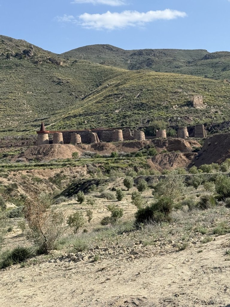 Reihe alter Brennöfen an einem Hang in einer trockenen Landschaft in Andalusien