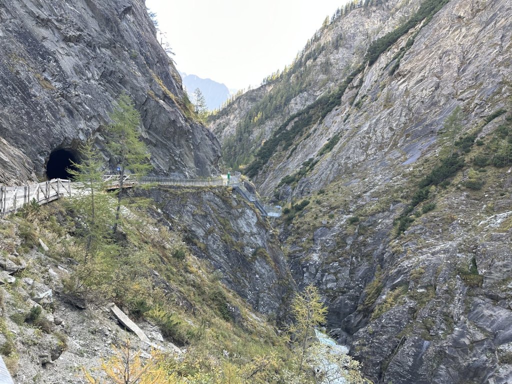 Gesicherter Steig mit Tunnelportal an einer Felswand über der Daberklamm