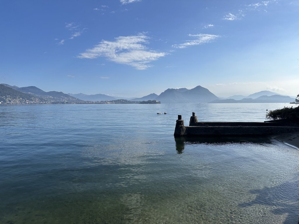 Ruhiger Lago Maggiore mit Steg und den Inseln im Hintergrund
