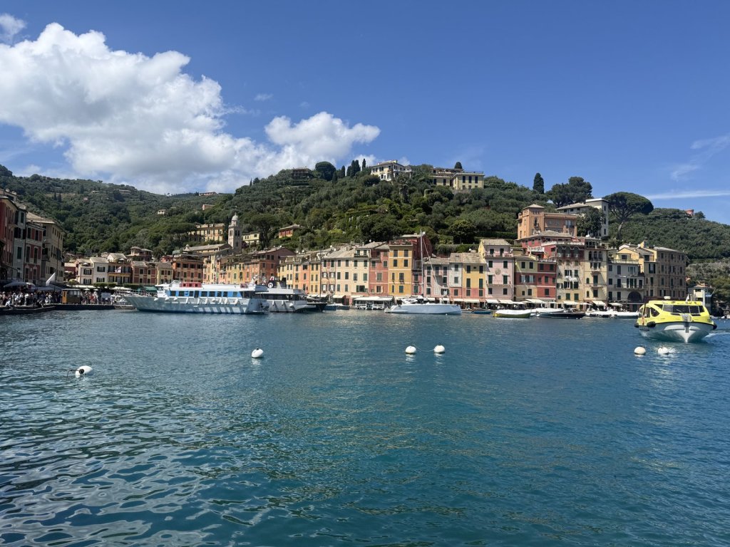 Bunte Häuserfront am Hafen von Portofino mit Ausflugsbooten
