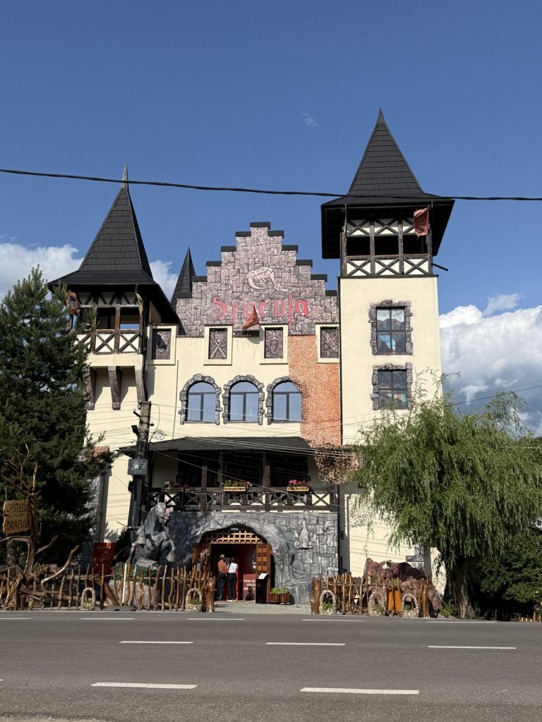 Burgartiges Gasthaus mit Türmchen und Stufengiebel an der Straße bei Perişani