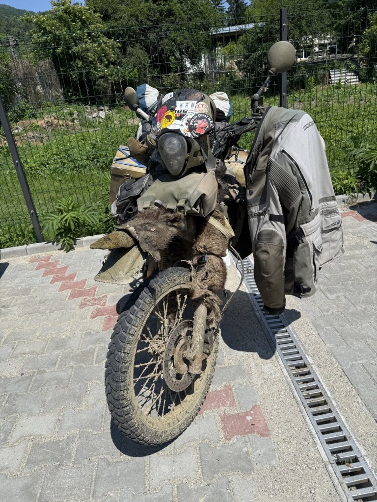 Stark verschmutztes Reisemotorrad mit Aufklebern auf Pflastersteinen