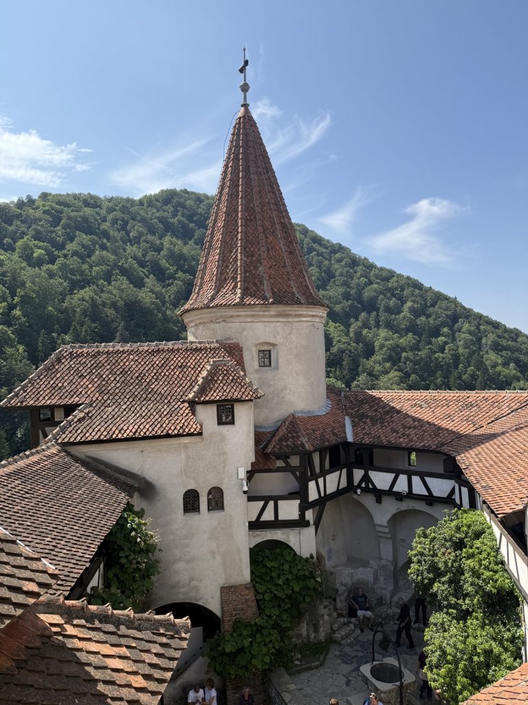 Innenhof von Schloss Bran mit Turm, Fachwerk und roten Ziegeldächern