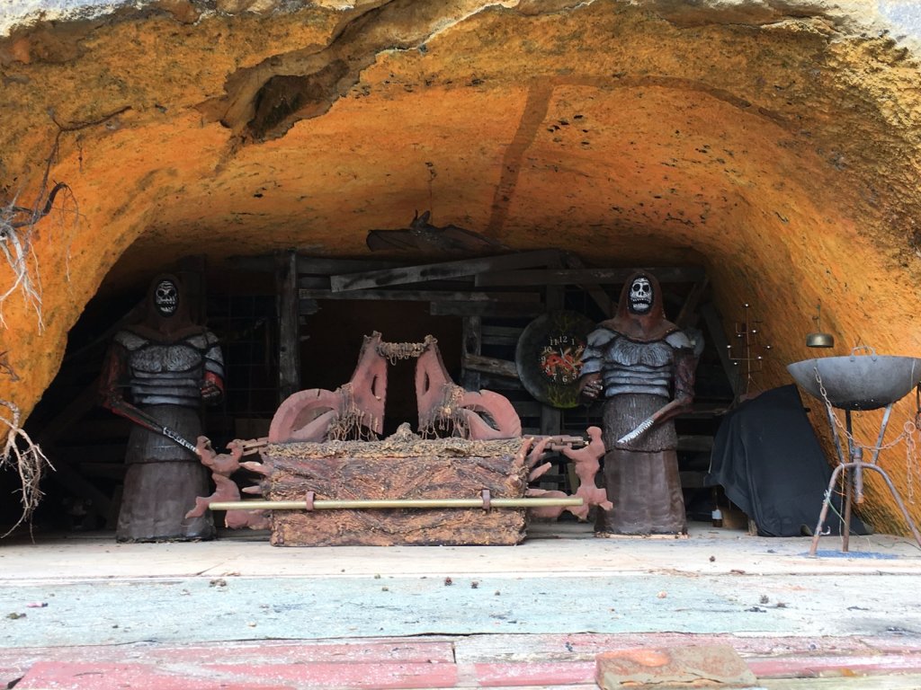 Zwei Figuren in Rüstung und ein Sofa in einer orangefarbenen Felsenhöhle