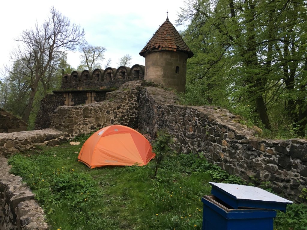 Orangefarbenes Zelt vor einer Burgmauer mit Wehrturm am Schloss Grodziec