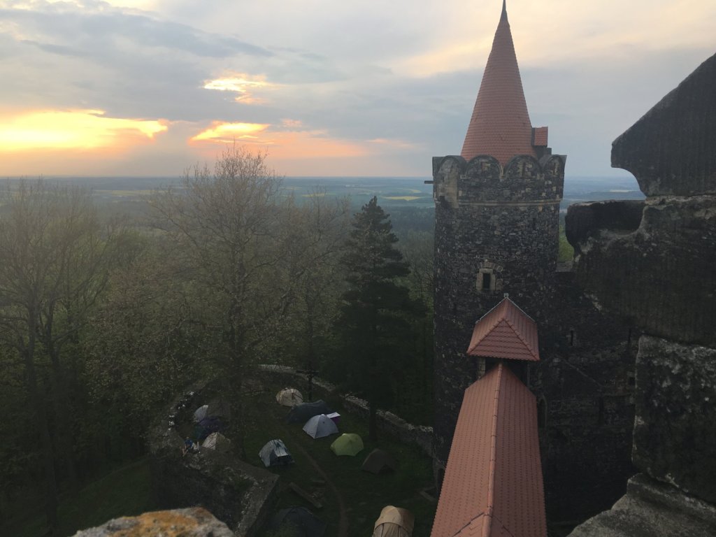 Burgturm mit rotem Turmdach im Abendlicht über dem Zeltplatz