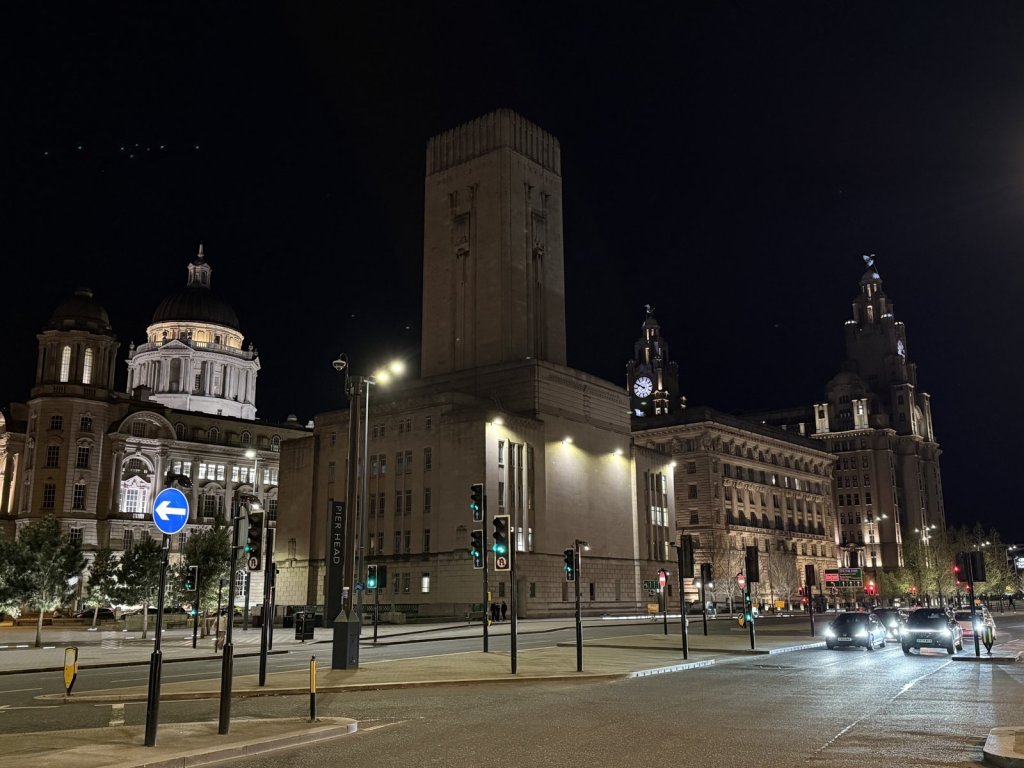 Beleuchteter Pier Head mit historischen Gebäuden in Liverpool bei Nacht