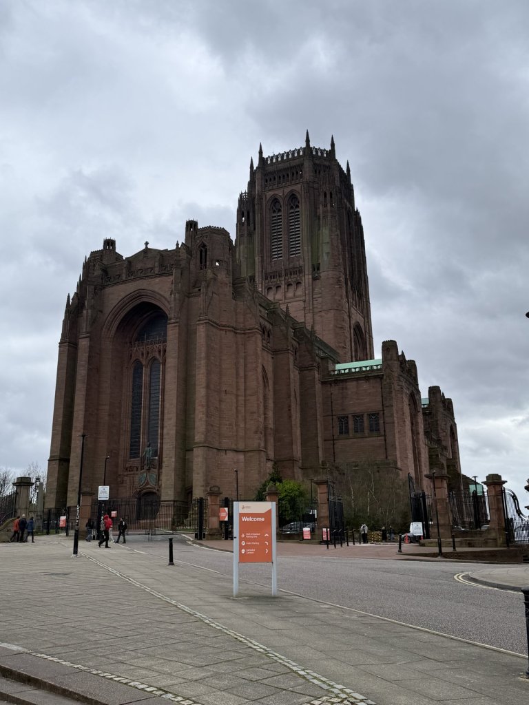 Gewaltige rote Backstein-Kathedrale von Liverpool unter wolkigem Himmel