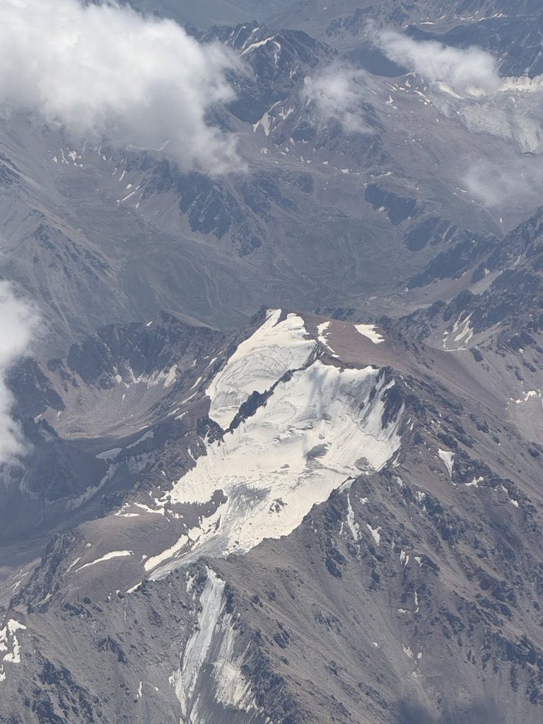 Schneebedeckte Gipfel und Gletscher aus dem Flugzeugfenster