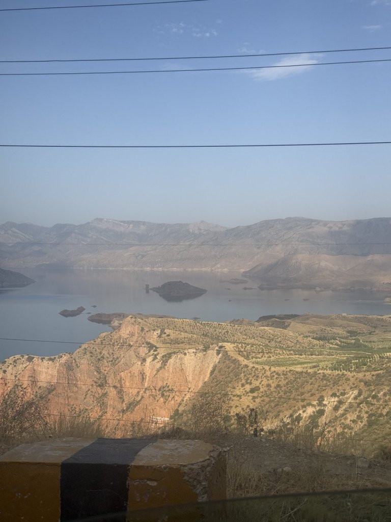 Türkiser Stausee mit Inseln zwischen trockenen Hügeln