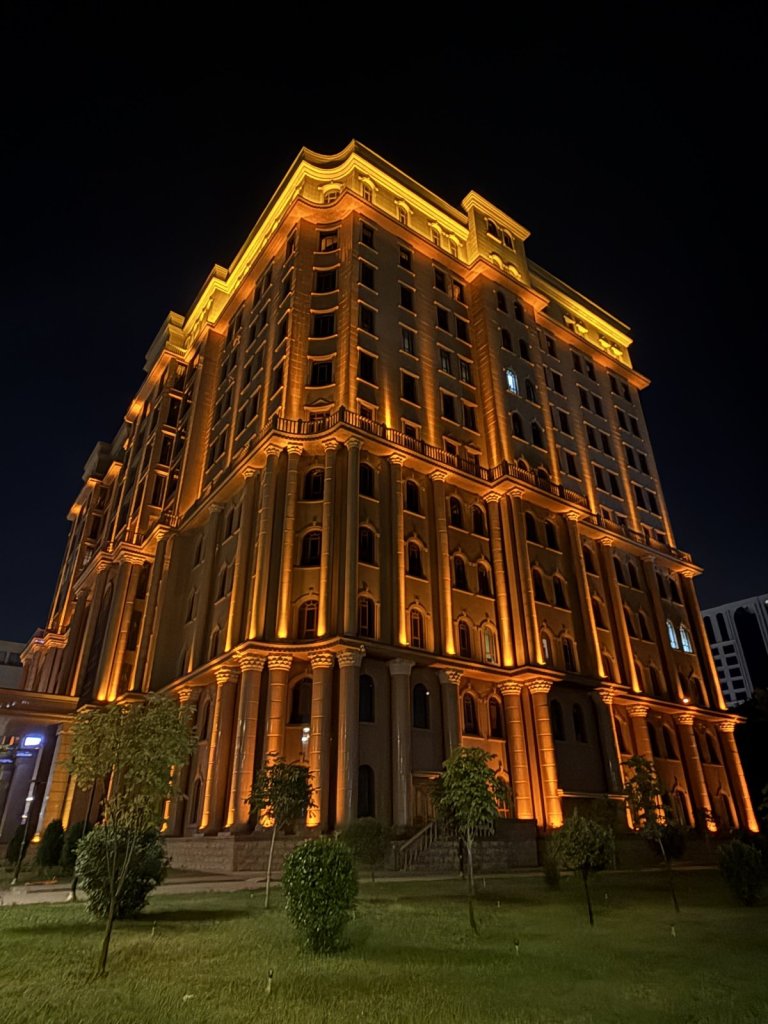 Goldgelb beleuchtetes Hochhaus im klassizistischen Stil bei Nacht