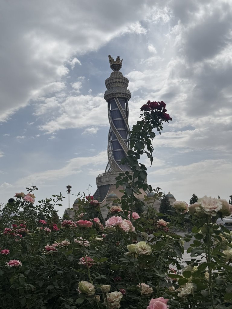 Turm mit Krone hinter blühenden Rosen