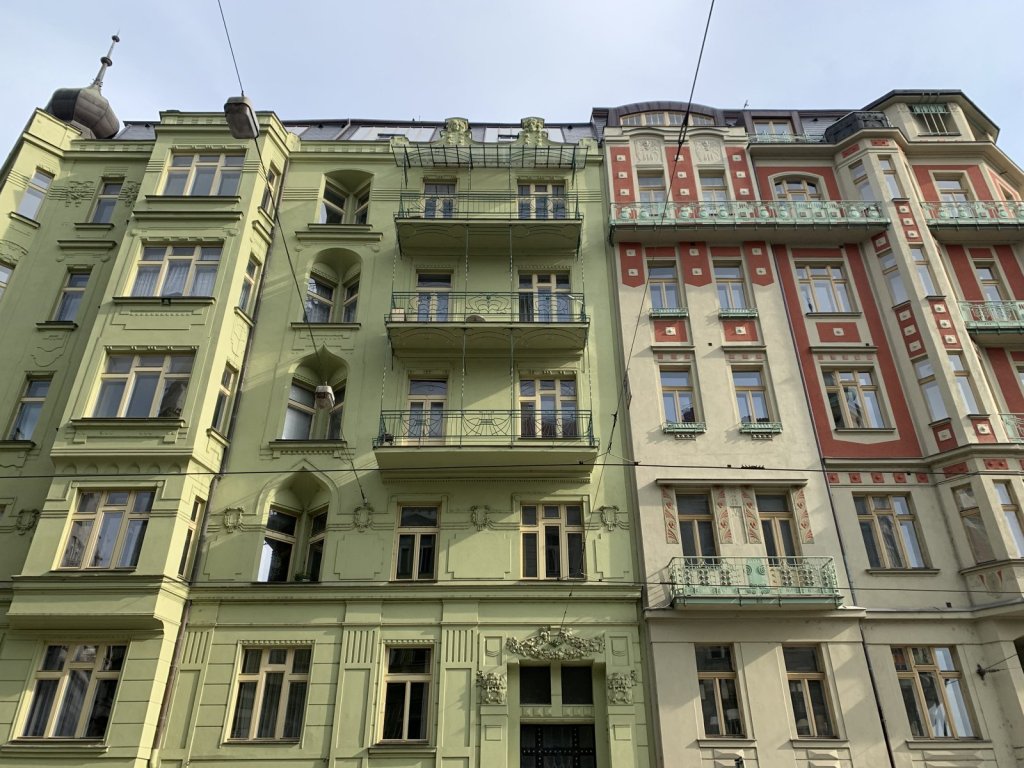 Hohe Jugendstilfassaden in grün und rot in Prag
