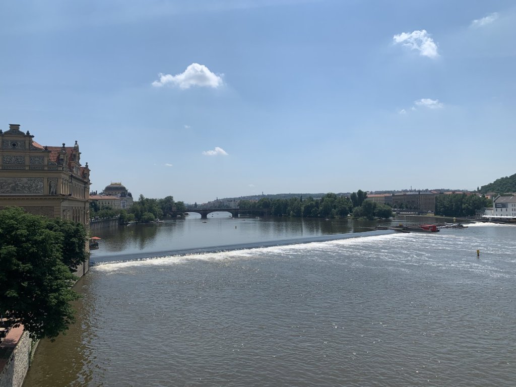 Blick über die Moldau mit einem Wehr und Brücken in Prag