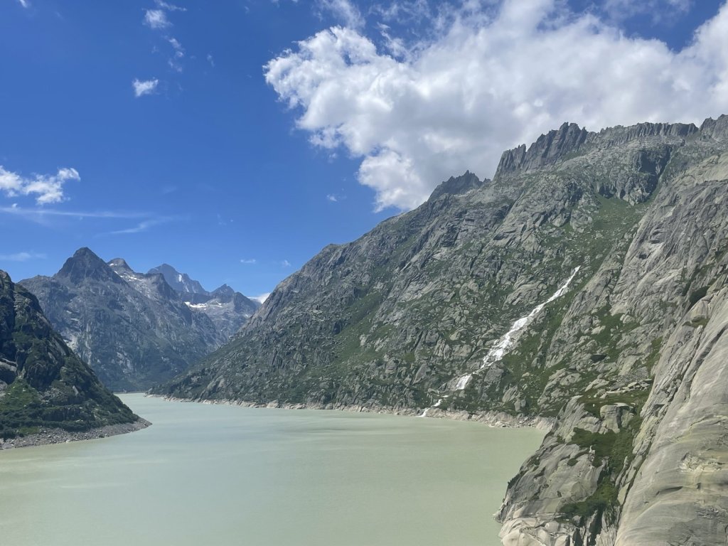 Hellgrüner Stausee zwischen steilen Felswänden