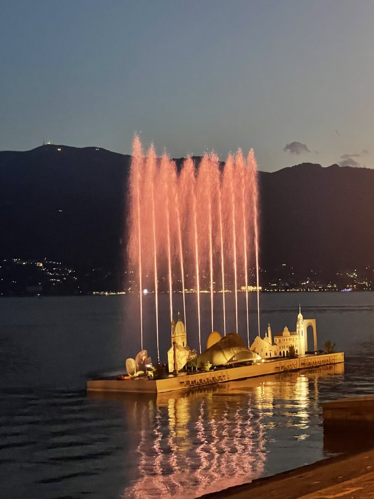Bunt beleuchtetes Wasserspiel auf dem Lago Maggiore bei Dämmerung