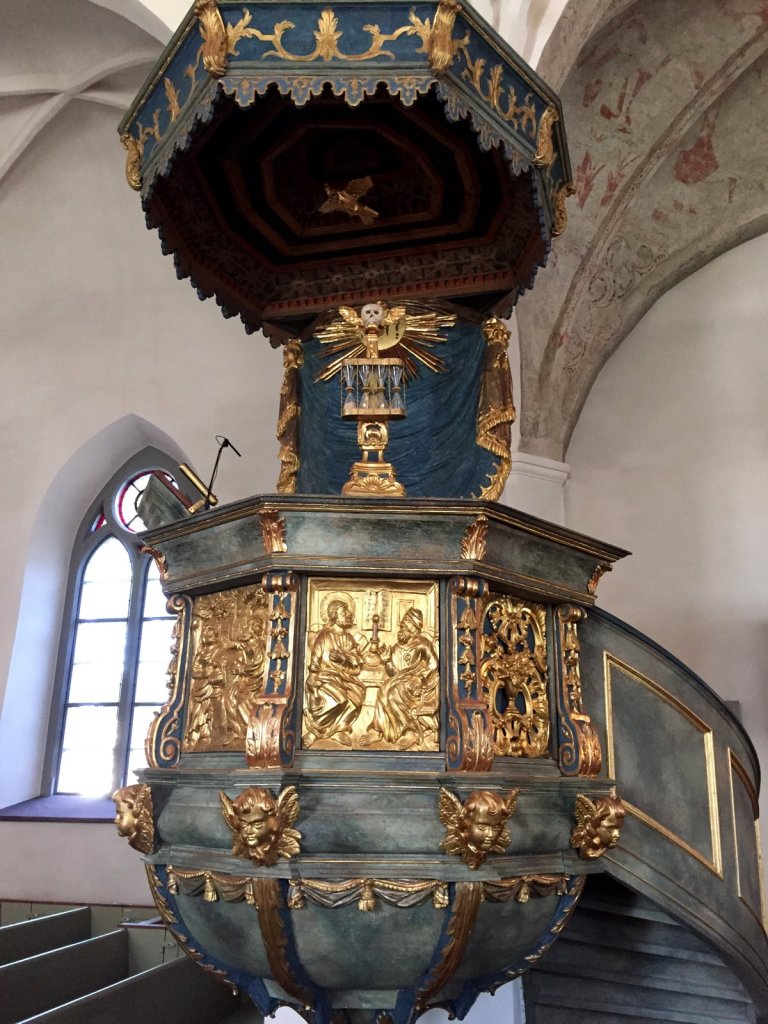 Prunkvolle blau-goldene Kanzel in einer weißen Kirche