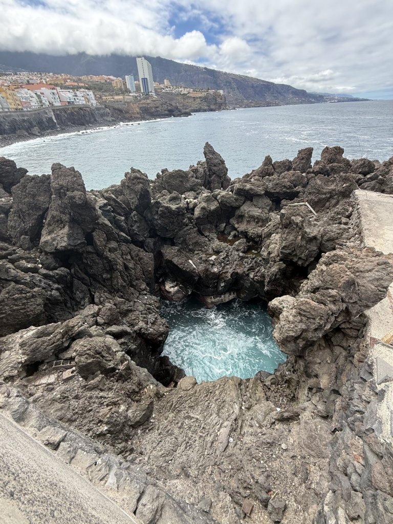 Meerwasserbecken zwischen schwarzen Lavafelsen an der Nordküste