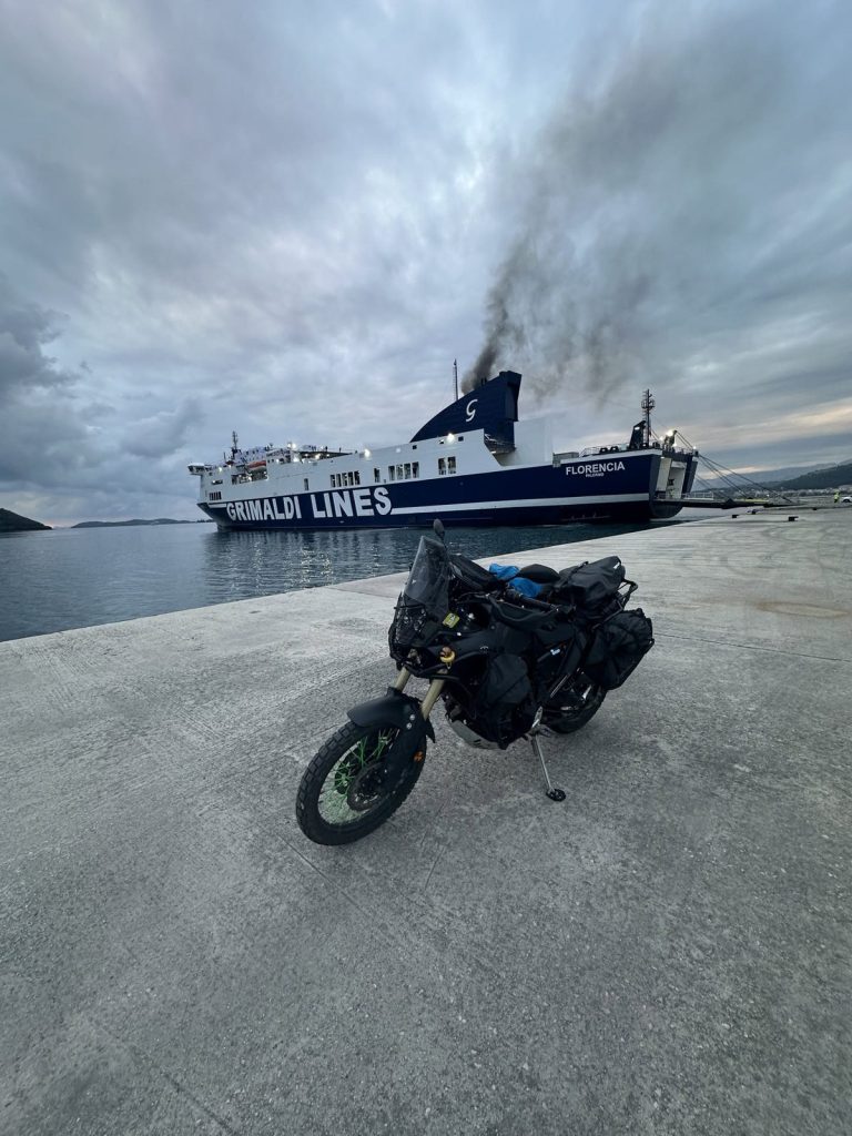 Beladenes Motorrad vor einer Fähre im Hafen von Igoumenitsa