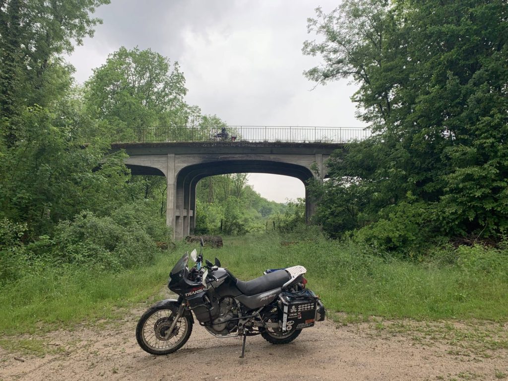 Honda Transalp vor einer Betonbrücke im Grünen
