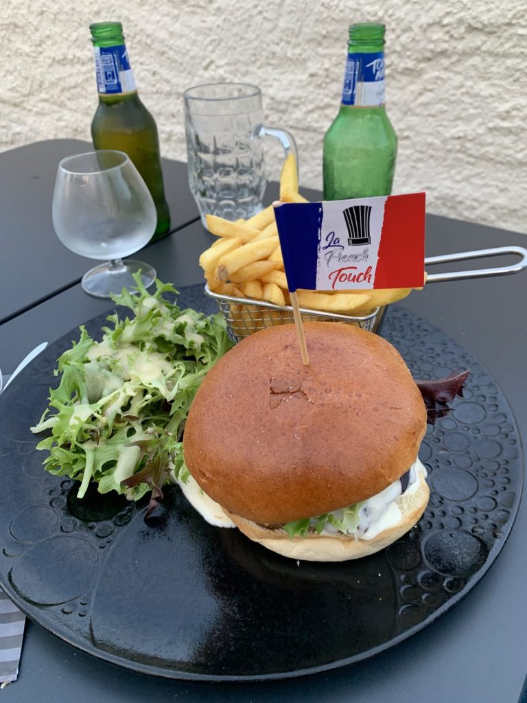 Burger mit Pommes und Salat, dazu ein Fähnchen in Blau-Weiß-Rot