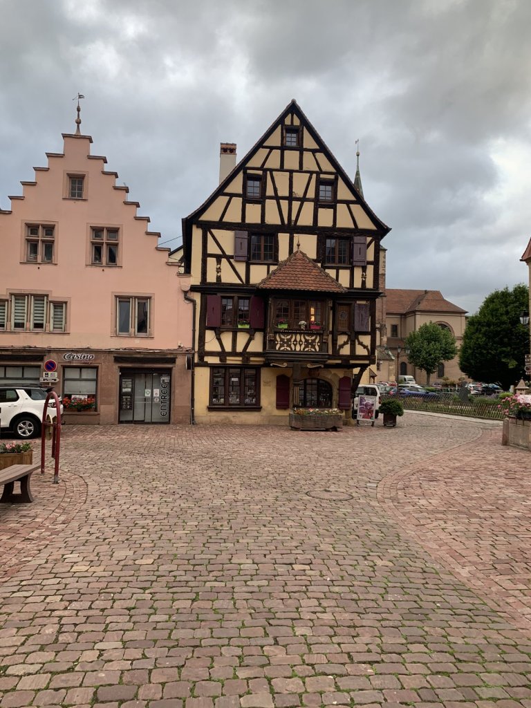 Gepflasterter Platz mit Fachwerkhaus und rosa Treppengiebel