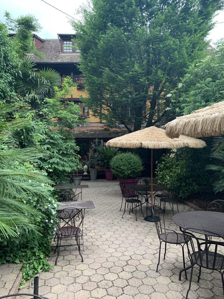 Innenhof mit Sonnenschirmen und Bistrotischen