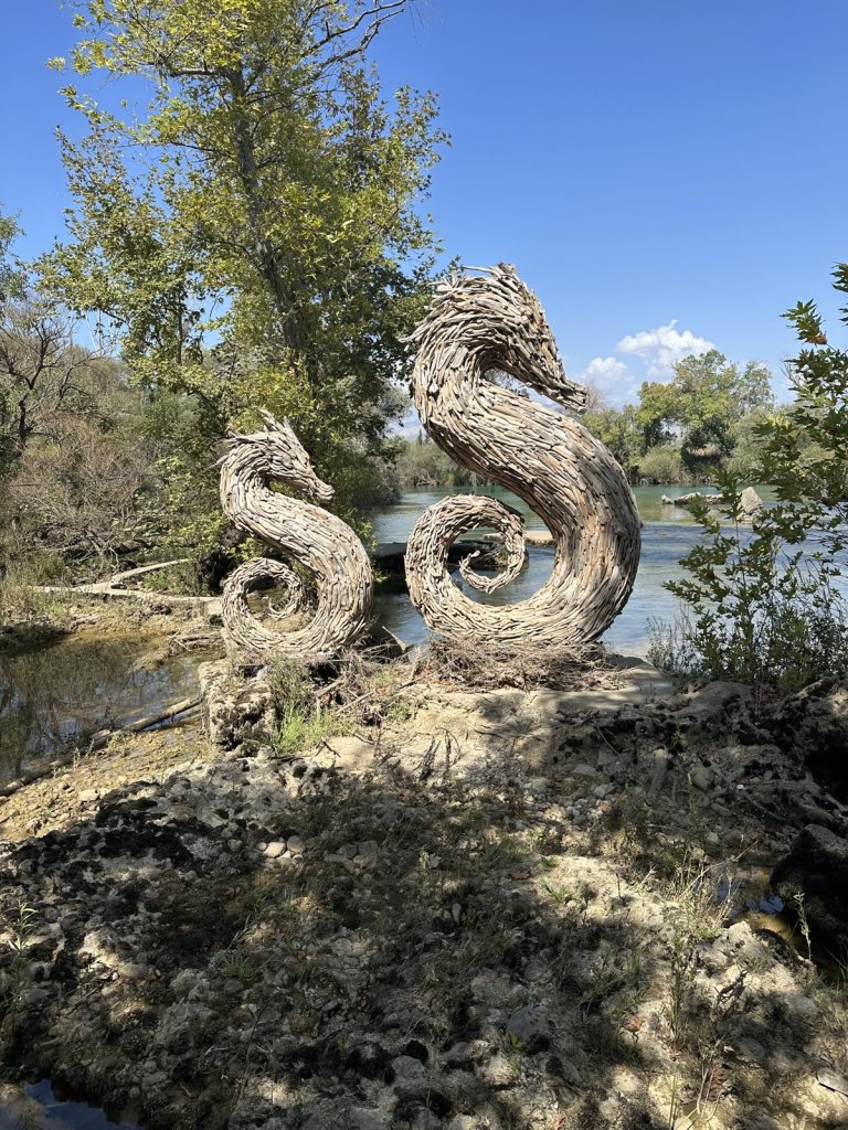 Skulptur zweier Seepferdchen aus Treibholz am Flussufer