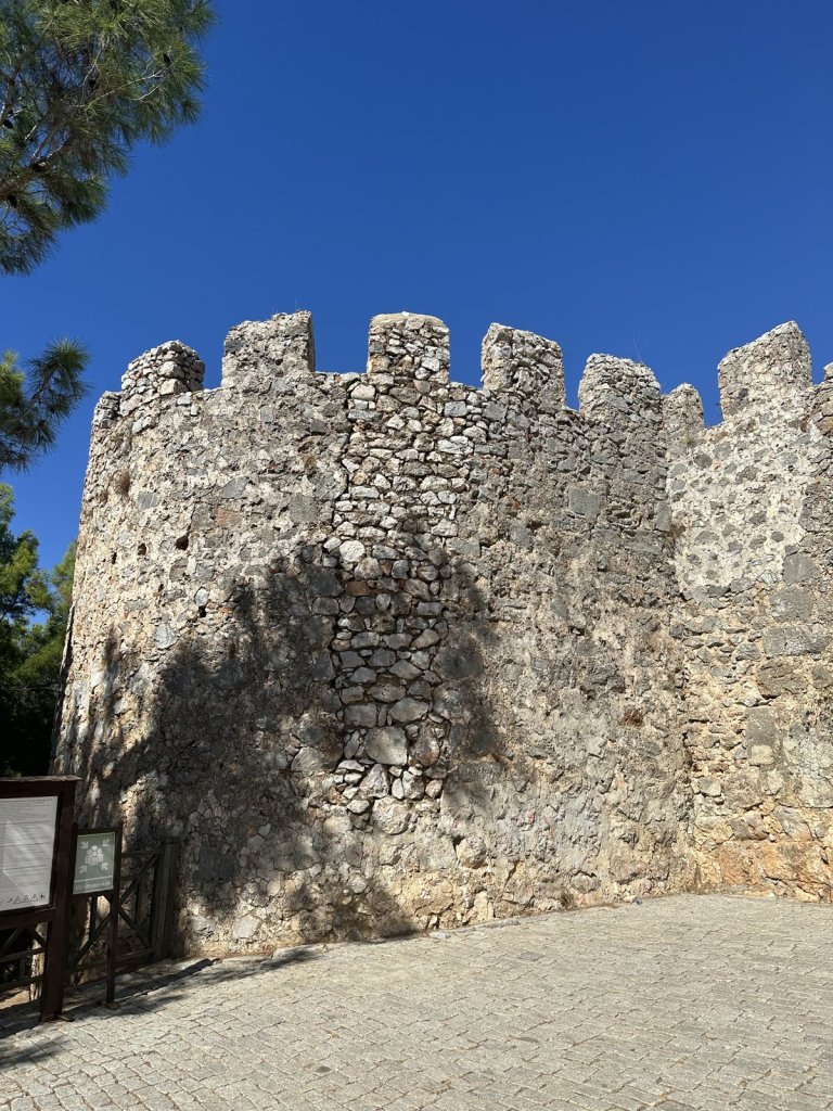 Zinnenbewehrter Turm der Burg von Alanya unter blauem Himmel