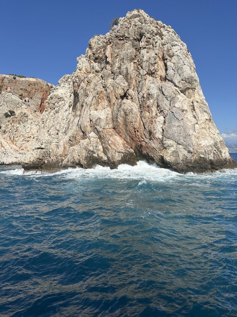 Hoher Felsen mit Brandung an der Küste von Alanya